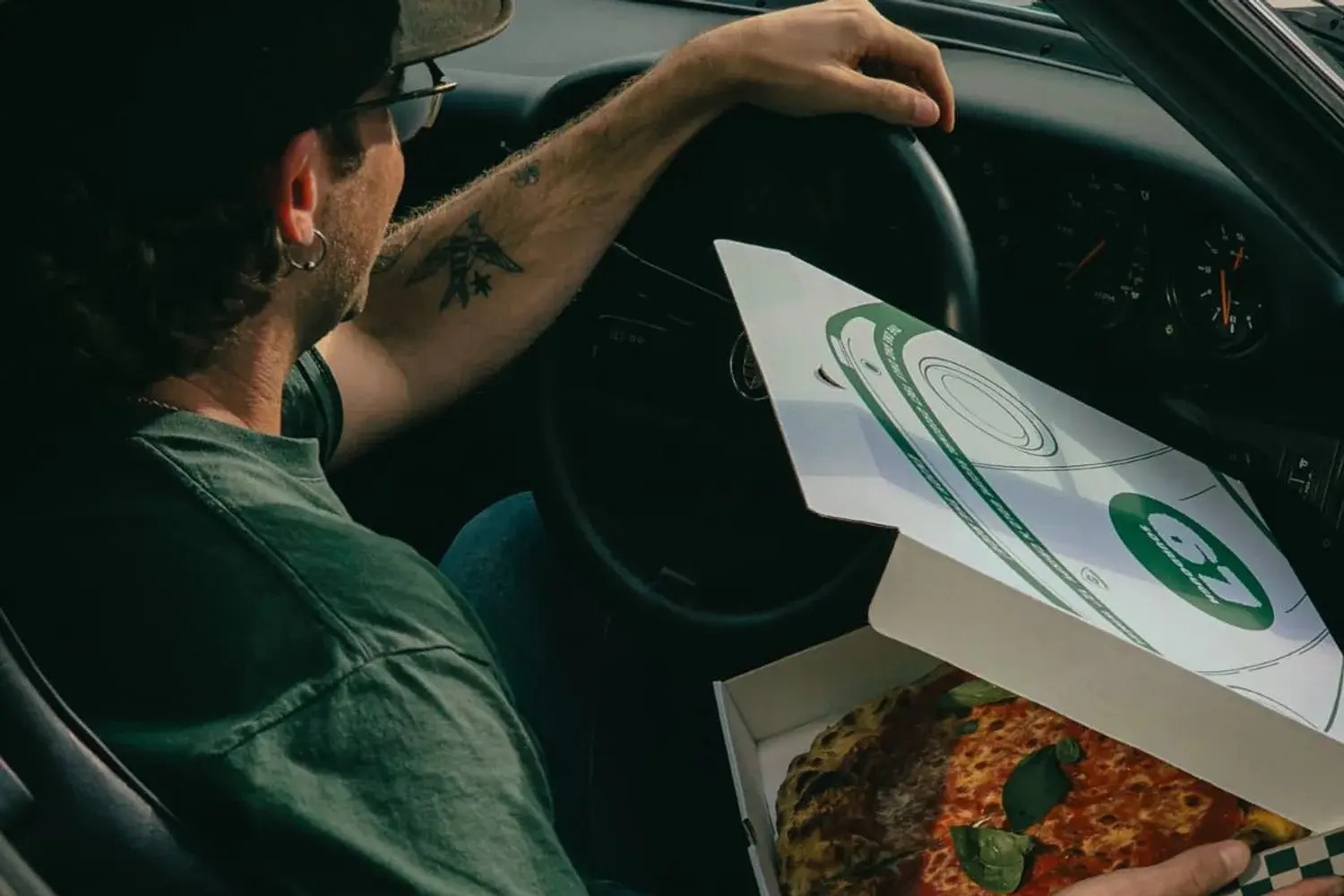 A 67 Sourdough pizza box open inside a classic Porsche